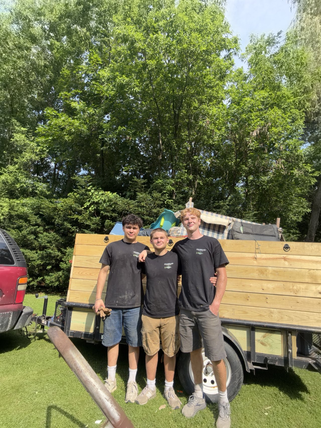 The Champlain Junk Removal crew in front of a loaded trailer